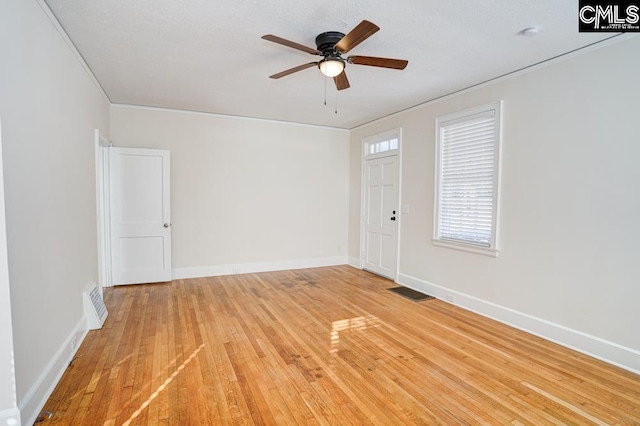 spare room with ornamental molding, light wood-type flooring, and ceiling fan