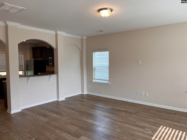 empty room with dark wood-type flooring and ornamental molding