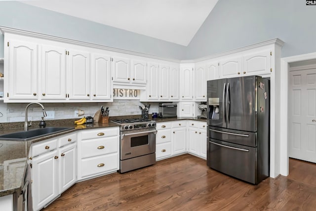 kitchen with appliances with stainless steel finishes, tasteful backsplash, sink, white cabinets, and dark wood-type flooring