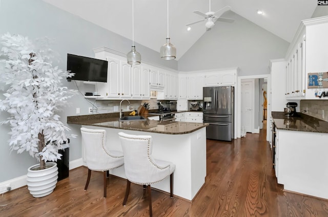 kitchen with sink, appliances with stainless steel finishes, backsplash, decorative light fixtures, and kitchen peninsula