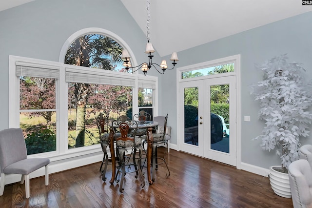 dining area with an inviting chandelier, high vaulted ceiling, dark wood-type flooring, and french doors