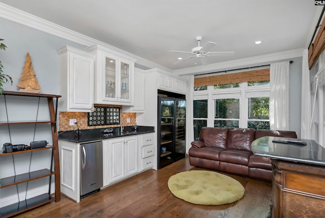 kitchen with dark wood-type flooring, fridge, ornamental molding, white cabinets, and decorative backsplash