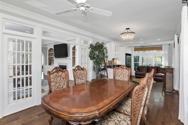 dining space featuring dark hardwood / wood-style flooring, ceiling fan with notable chandelier, and ornamental molding