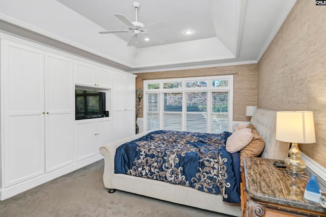 carpeted bedroom featuring crown molding, ceiling fan, and a tray ceiling