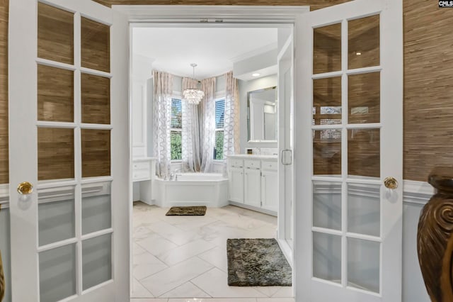 bathroom featuring vanity, a bathtub, and a notable chandelier