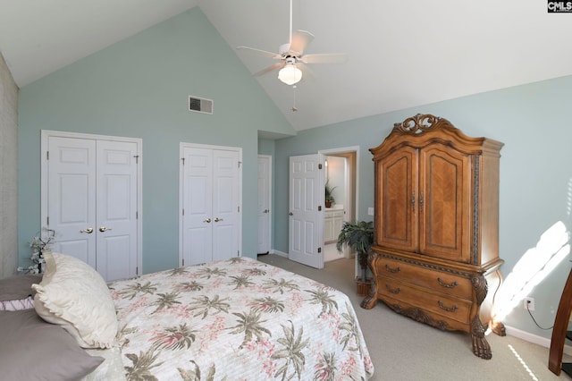 bedroom featuring ceiling fan, high vaulted ceiling, light carpet, and two closets