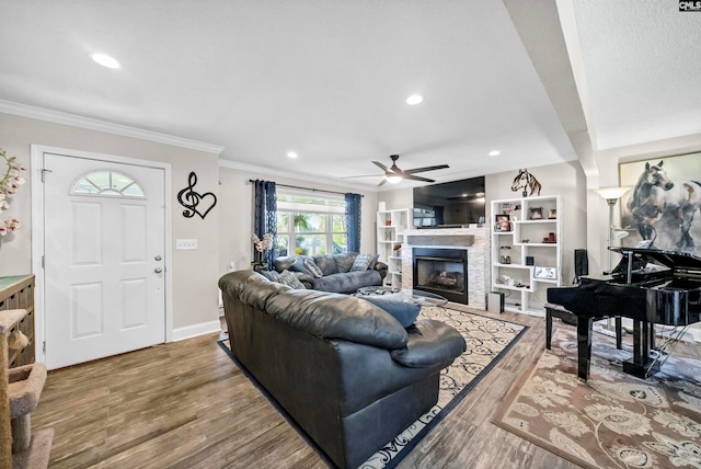 living room with hardwood / wood-style floors, crown molding, and ceiling fan