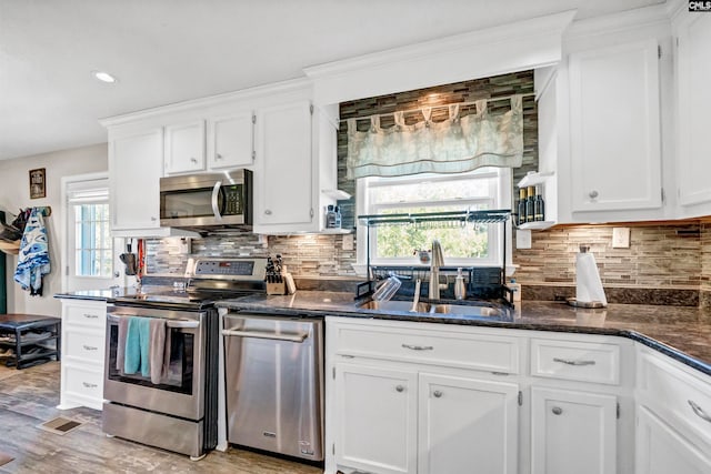 kitchen featuring sink, appliances with stainless steel finishes, white cabinetry, and plenty of natural light