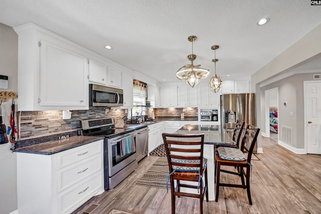 kitchen with light hardwood / wood-style floors, white cabinets, stainless steel appliances, and sink