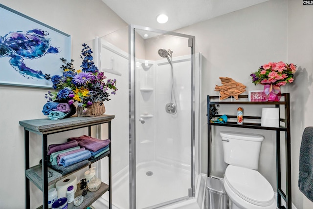 bathroom featuring toilet and an enclosed shower