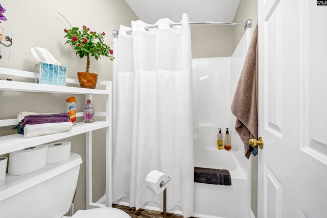 bathroom featuring toilet and walk in shower