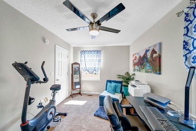 workout area featuring a textured ceiling, carpet flooring, and ceiling fan