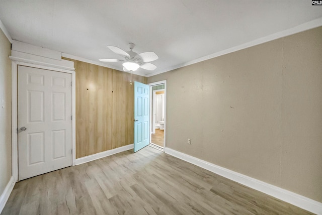 unfurnished bedroom featuring ceiling fan, crown molding, and light wood-type flooring