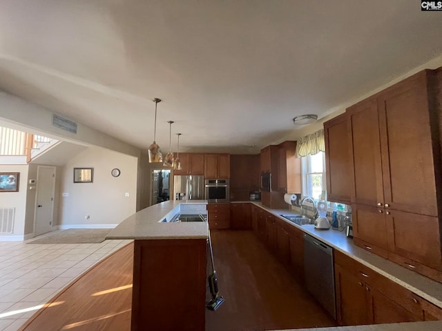 kitchen with lofted ceiling, a center island, light tile patterned flooring, pendant lighting, and appliances with stainless steel finishes