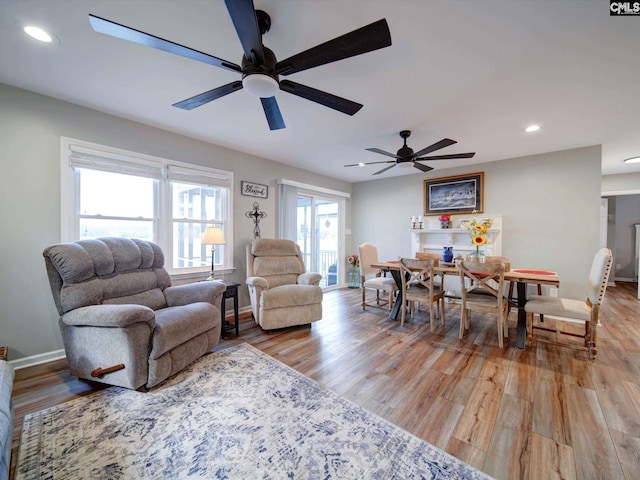 living room with light wood-type flooring and ceiling fan