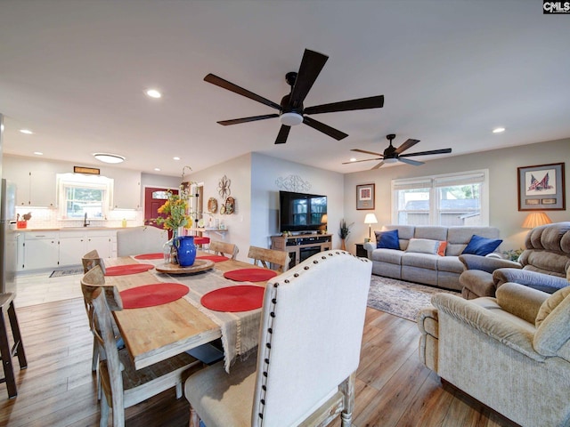 dining area with ceiling fan, sink, and light wood-type flooring