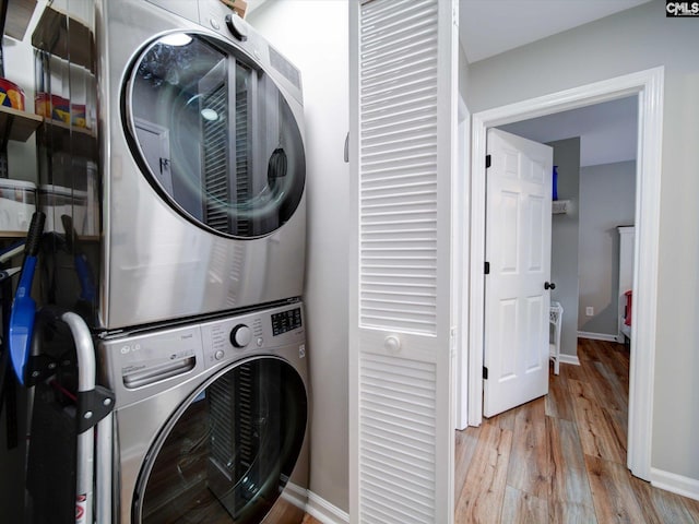 laundry room featuring stacked washer / dryer and light wood-type flooring