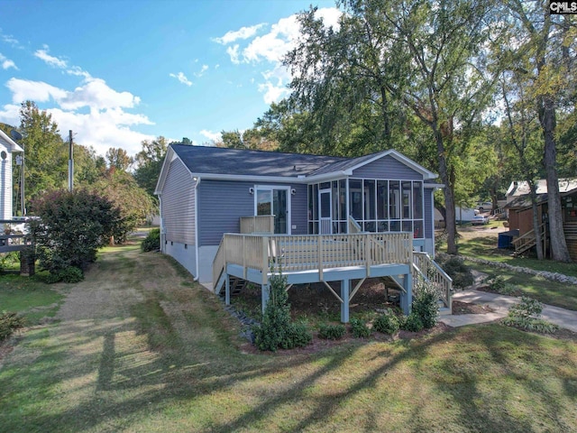 back of property featuring a yard and a sunroom