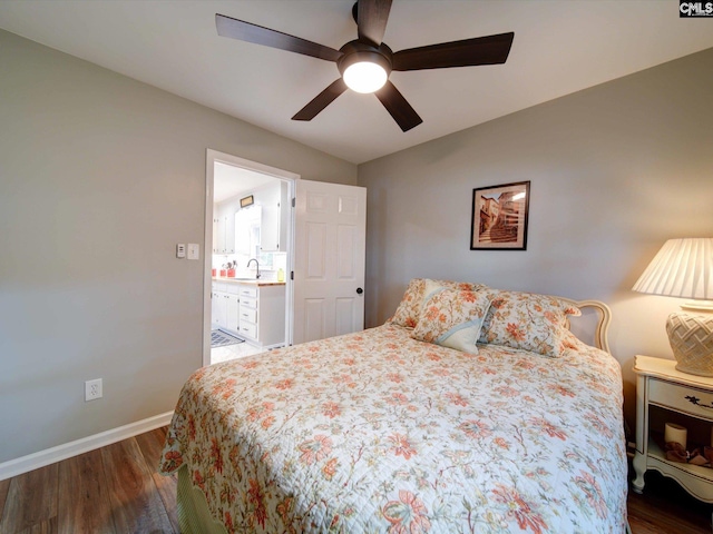 bedroom featuring lofted ceiling, ceiling fan, dark hardwood / wood-style floors, ensuite bath, and sink