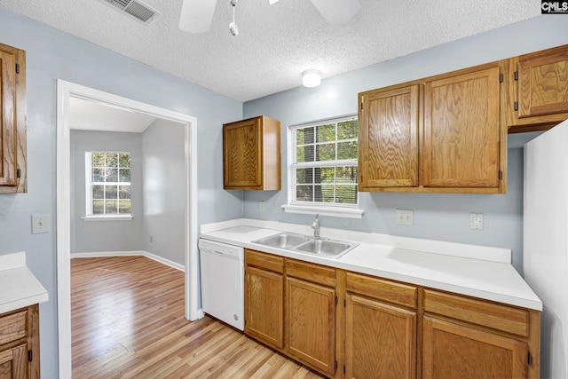 kitchen with white appliances, light hardwood / wood-style flooring, a textured ceiling, and sink