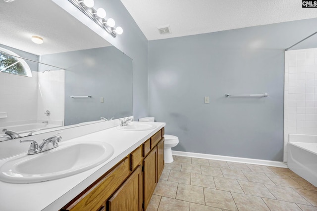 full bathroom with a textured ceiling, toilet, vanity, tiled shower / bath combo, and tile patterned flooring