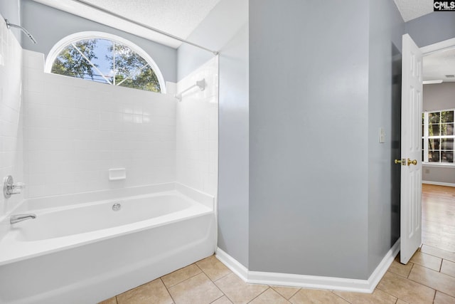 bathroom featuring a textured ceiling, bathing tub / shower combination, and tile patterned flooring