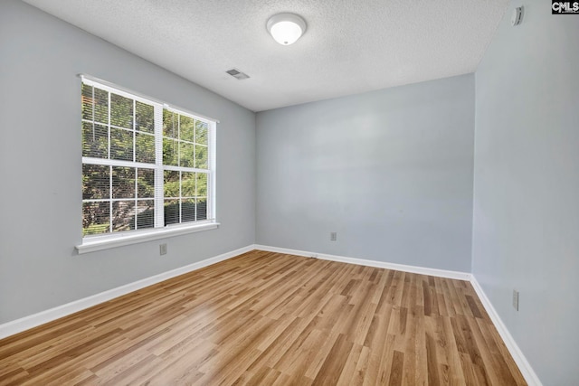 unfurnished room featuring light hardwood / wood-style floors and a textured ceiling