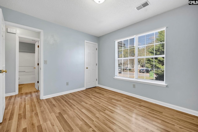 unfurnished bedroom featuring light hardwood / wood-style floors and a textured ceiling