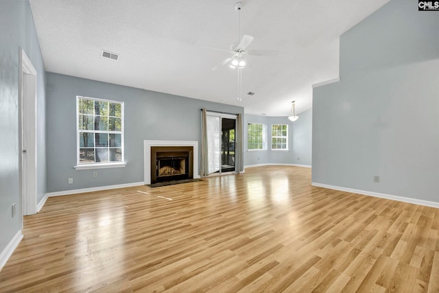 unfurnished living room with ceiling fan, a healthy amount of sunlight, and light wood-type flooring