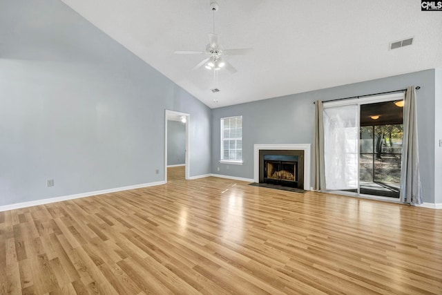 unfurnished living room featuring a textured ceiling, high vaulted ceiling, light hardwood / wood-style floors, and ceiling fan