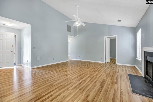 unfurnished living room with light hardwood / wood-style flooring, a textured ceiling, high vaulted ceiling, and ceiling fan