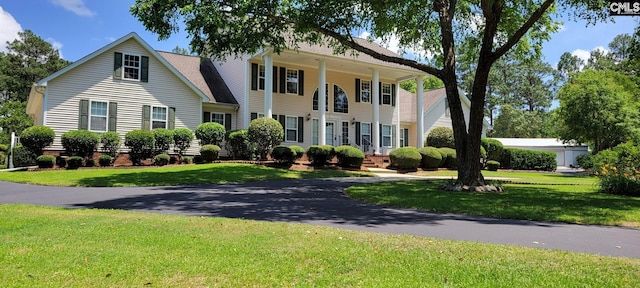 colonial-style house featuring a front lawn