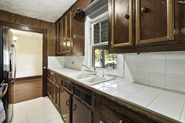 6560 Voorhees Rd, Denmark, SC 29042 - kitchen with tile countertops, stainless steel fridge, backsplash, and light tile patterned flooring