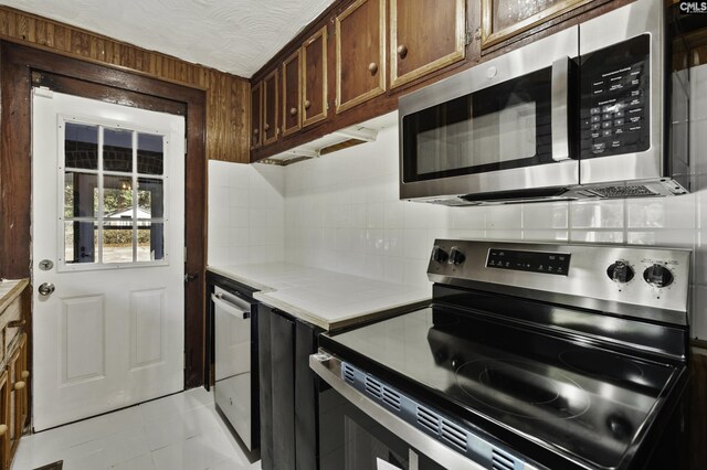 6560 Voorhees Rd, Denmark, SC 29042 - kitchen with stainless steel appliances, backsplash, brown cabinets, light countertops, and light tile patterned floors