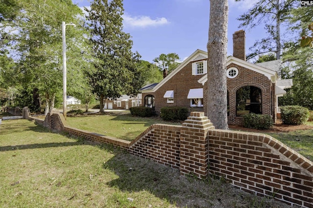 6560 Voorhees Rd, Denmark, SC 29042 - view of front of home featuring a chimney, a front lawn, and brick siding