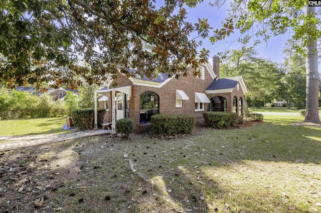 6560 Voorhees Rd, Denmark, SC 29042 - view of front facade featuring brick siding, a front yard, and a chimney