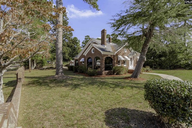 6560 Voorhees Rd, Denmark, SC 29042 - view of front of property with a front yard, a chimney, and brick siding