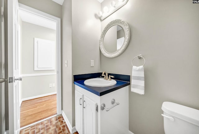 bathroom featuring vanity, toilet, and hardwood / wood-style flooring