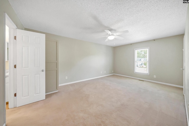 carpeted spare room with a textured ceiling and ceiling fan