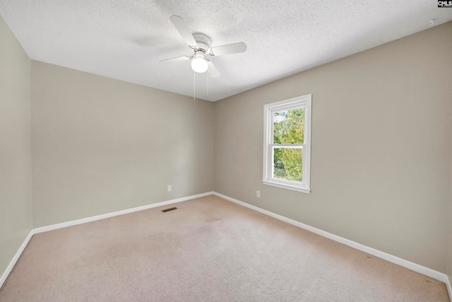 carpeted spare room with a textured ceiling and ceiling fan