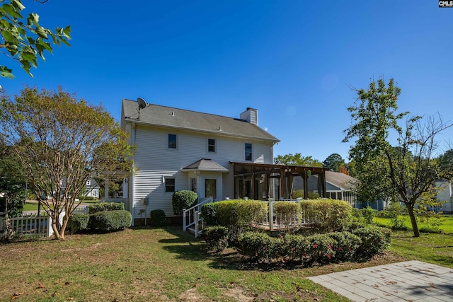 rear view of house featuring a lawn