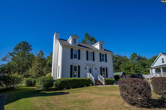 colonial inspired home featuring a front yard