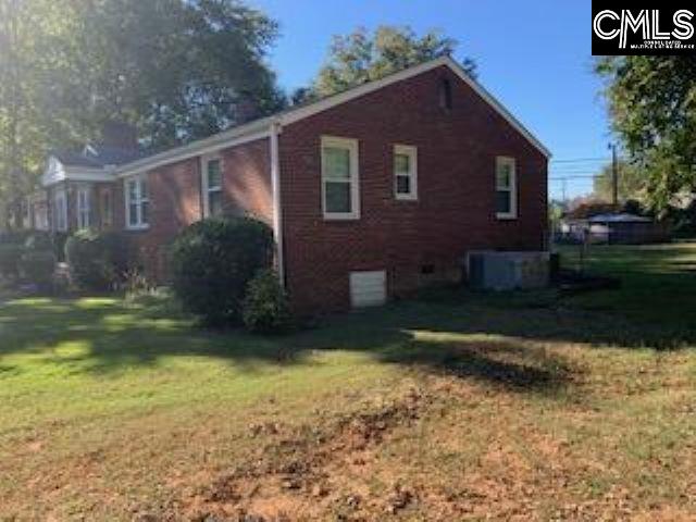 view of side of home with a lawn and cooling unit