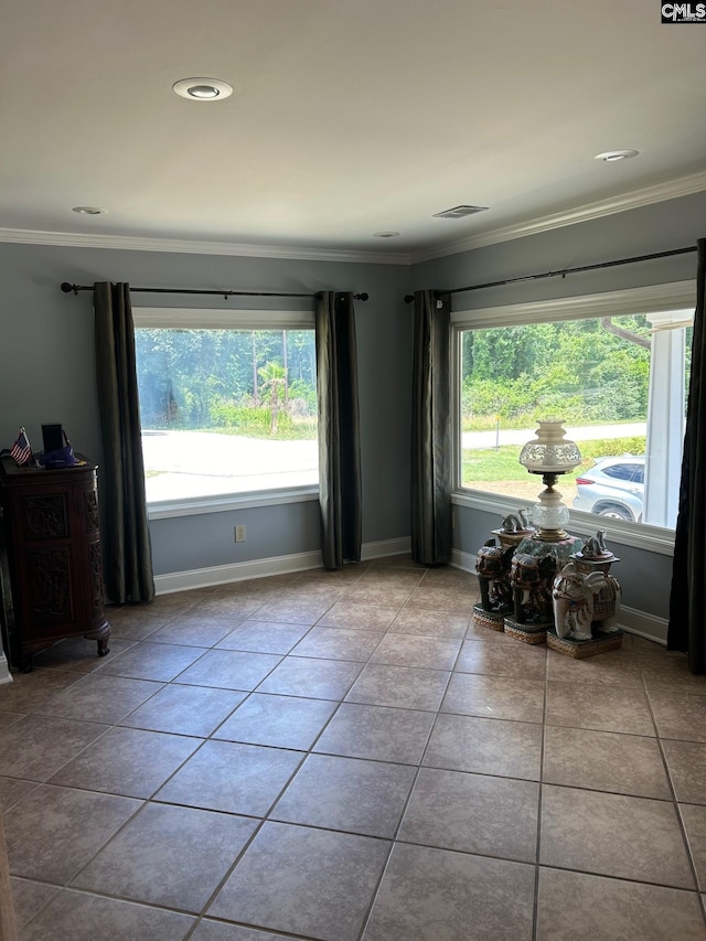 unfurnished room featuring crown molding, plenty of natural light, and light tile patterned floors