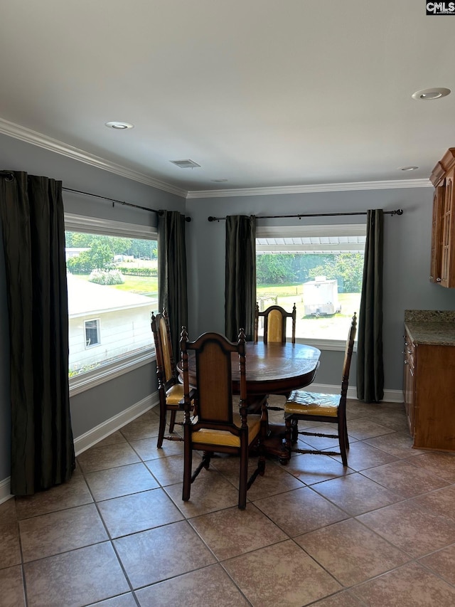 tiled dining room with a wealth of natural light and crown molding