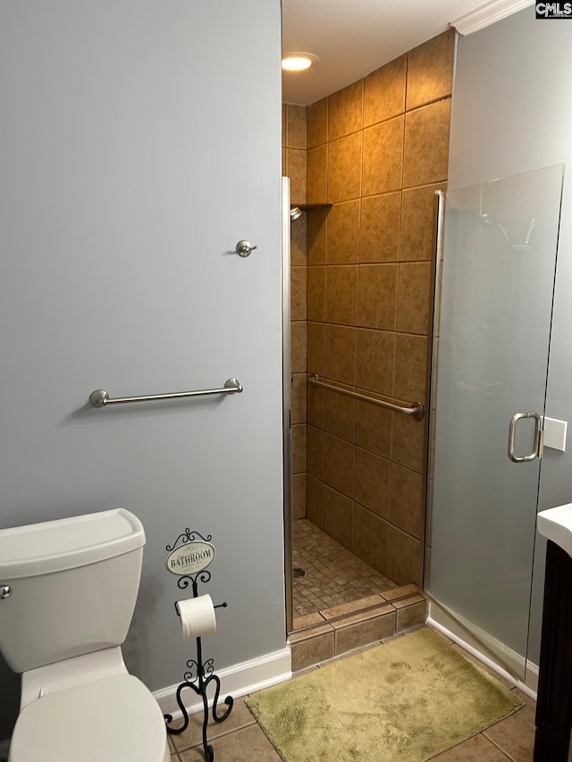 bathroom with toilet, vanity, tile patterned floors, and a shower with door