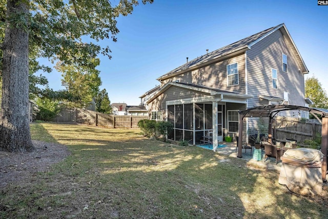 back of house featuring a sunroom, a lawn, and a pergola