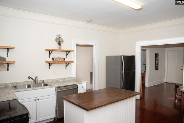 kitchen featuring white cabinetry, wood counters, ornamental molding, sink, and stainless steel appliances