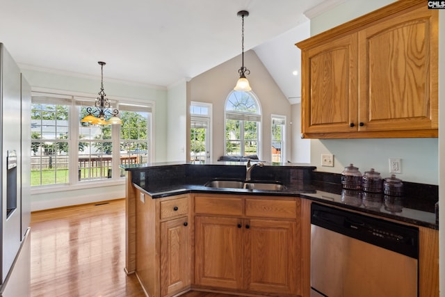 kitchen featuring dark stone countertops, sink, a notable chandelier, pendant lighting, and appliances with stainless steel finishes