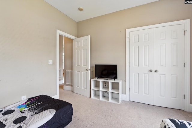 bedroom with a closet and light colored carpet